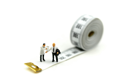 Miniature people : Doctor and patient with tape Measure,Healthcare and diet concept.